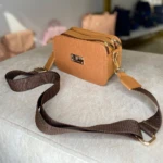 Bolso bandolera Karla Chacon Evah miel, textura cocodrilo, con correa ajustable café oscuro y herrajes dorados.