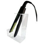Plancha de cabello profesional negra y verde lima en soporte organizador acrílico transparente.