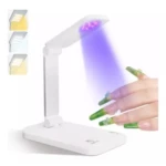 Lámpara plegable blanca de 24W para uñas, con luz ultravioleta encendida sobre una mano, incluye opción de luz cálida y blanca para escritorio.