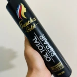 Botella negra de repolarizador capilar French's Gold Oil Total Repair 500ml, en mano.