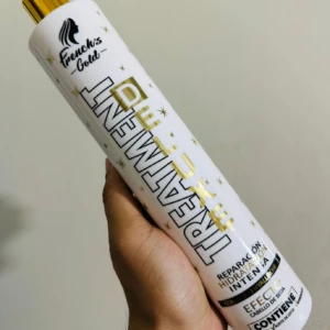 Tratamiento capilar blanco con letras doradas "Treatment", contiene ácido hialurónico.