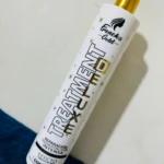 Botella blanca de tratamiento capilar French's Gold con tapa dorada, texto negro y dorado, efecto seda.
