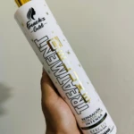 Botella blanca de tratamiento capilar French's Gold con tapa dorada, detalles de estrellas doradas y texto negro y dorado.
