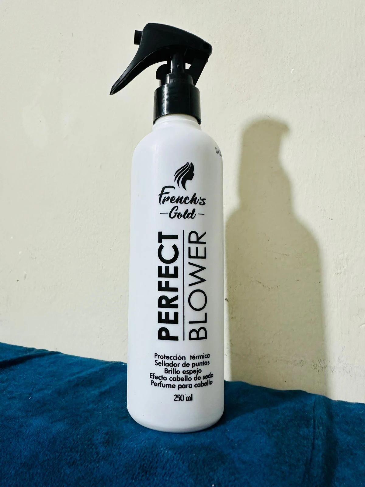 Termo protector capilar French's Gold Perfect Blower en botella blanca con atomizador negro, sella puntas y da brillo.