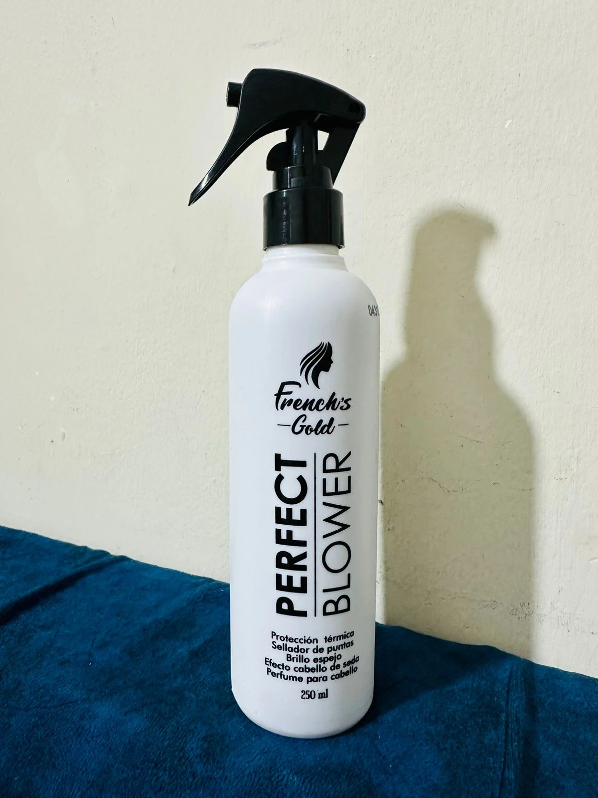Botella blanca de French's Gold Perfect Blower 250ml con atomizador negro, sella puntas y da brillo.