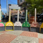 Set de escoba y recogedor con diseños infantiles de frutas y animales en colores vivos, perfecto para limpieza.