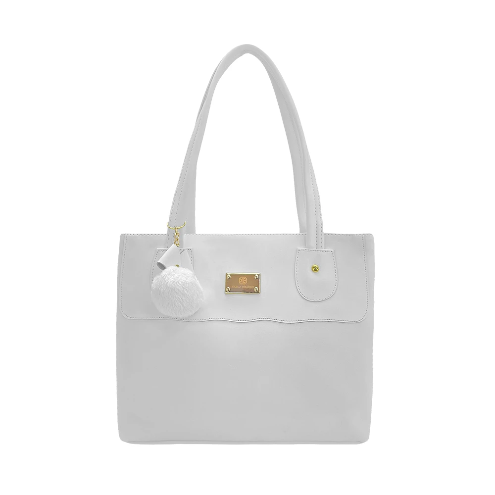 Bolso de mano tipo tote blanco liso, con asas, placa dorada de marca y dije de pompón peluche blanco.