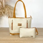 Bolso tote dama color beige claro con detalles en café caramelo y monedero a juego, sobre mesa de madera clara.