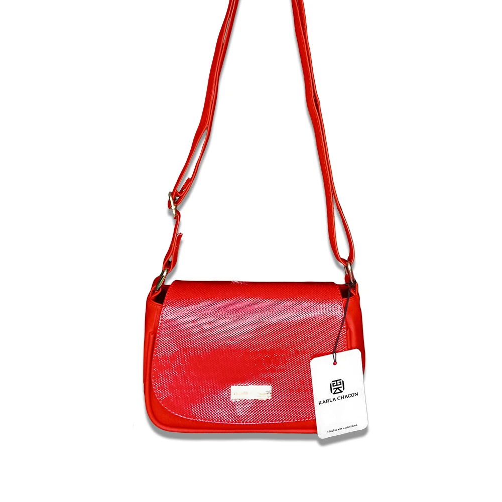 Bolso cruzado rojo charol texturizado Karla Chacón, con correa ajustable y etiqueta colgante.