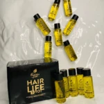 Caja negra con logo dorado de "French's Gold HAIR LIFE SHOT" y 10 ampolletas pequeñas de aceite capilar amarillo.