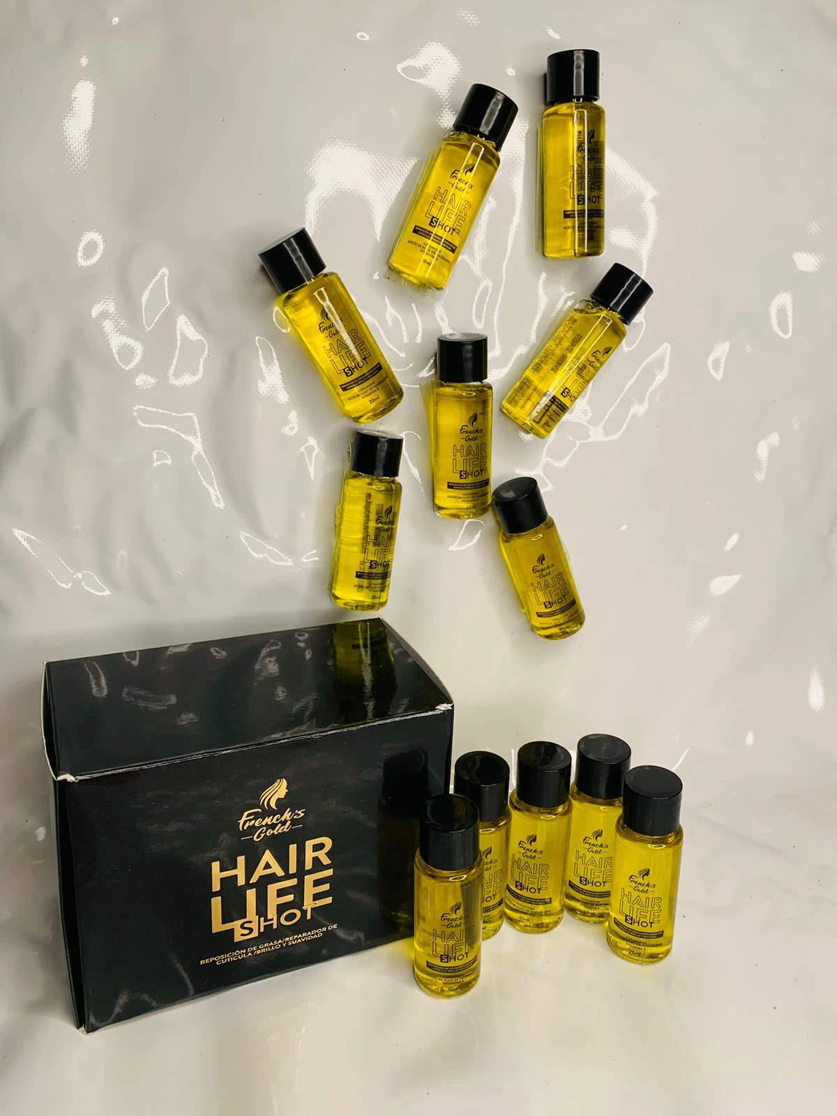 Caja negra con 12 ampolletas de aceite capilar dorado "Hair Life Shot".