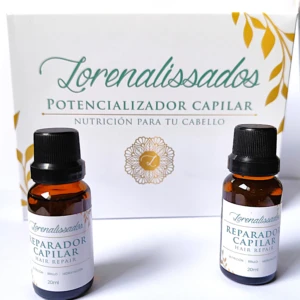 Dos frascos ámbar de 20ml de tratamiento capilar con tapa negra. Caja blanca con diseño de hojas doradas.