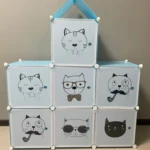 Armario organizador azul claro con 7 cubos, cada uno con un diseño de gato diferente, ideal para ropa y juguetes.
