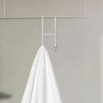 Gancho cromado para puerta, ideal para colgar toallas en baño o cocina.