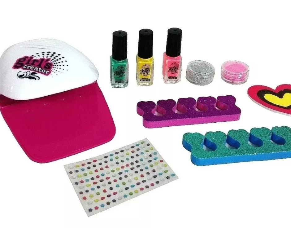 Set de manicura infantil que incluye secador de uñas fucsia y blanco, tres esmaltes, purpurina, dos separadores de dedos, adhesivos decorativos y lima.