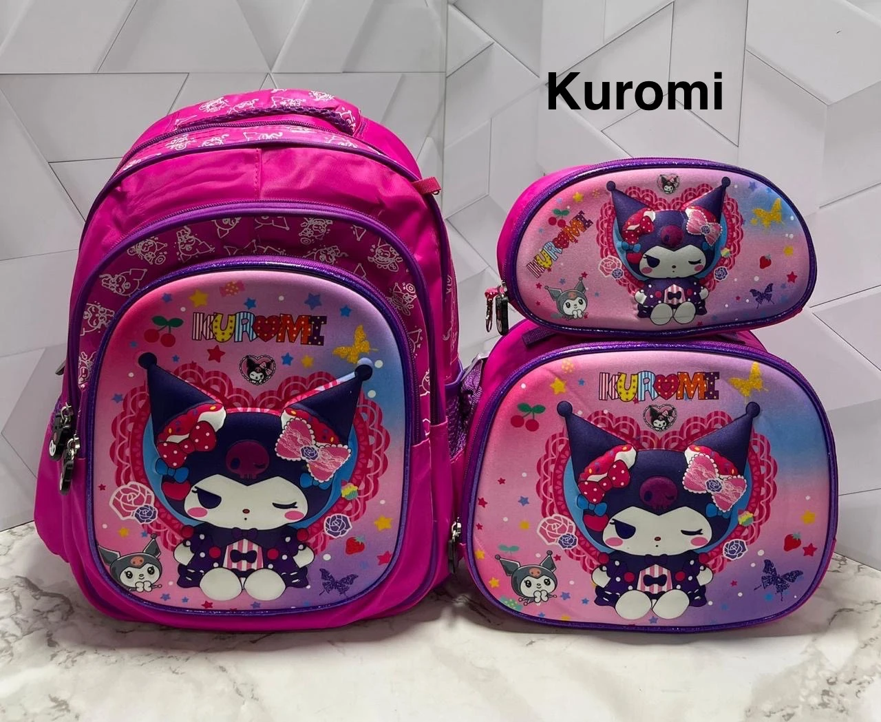 Trío escolar Kuromi fucsia: morral grande, lonchera y cartuchera a juego con diseño 3D de personaje Sanrio.