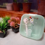 Lonchera cuadrada pequeña verde menta con diseño de oso y cuchara.