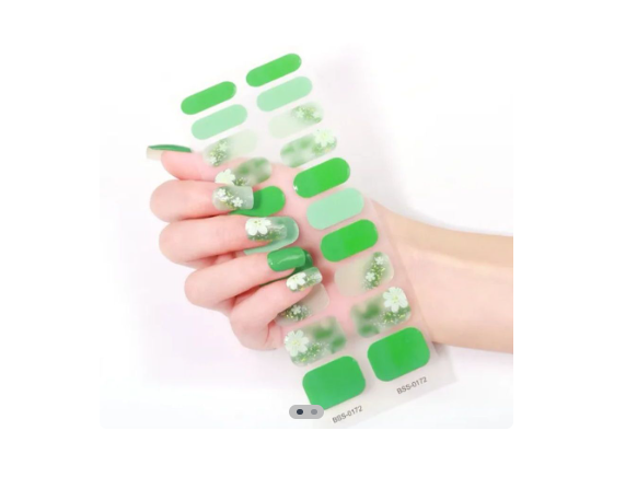 Stickers de uñas en gel verdes con diseño floral, aplicados en mano para manicura profesional en casa.