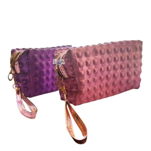 Cartuchera/cosmetiquera mujer morada y rosa con textura de tachas y correa dorada.