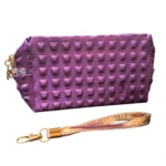 Cartuchera morada con relieve de pirámides y correa dorada, para cosméticos.