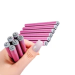 Set de seis pinceles de silicona con puntas moldeadoras para diseño de uñas, color fucsia, sostenidos por una mano para mostrar sus diferentes relieves.