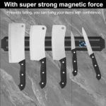 Barra magnética negra con cinco cuchillos (tres hachas y dos cuchillos) sujetos sobre fondo de mármol gris.