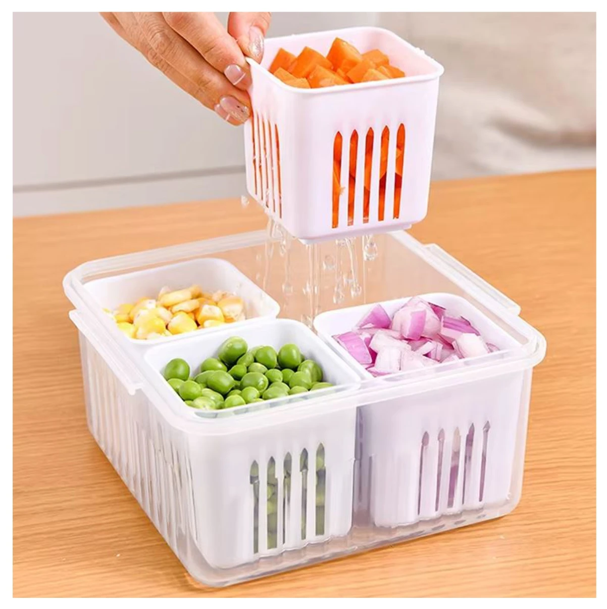 Organizador multipropósito de alimentos con recipiente transparente y cuatro cestas blancas extraíbles con ranuras, conteniendo zanahoria, maíz, guisantes y cebolla.