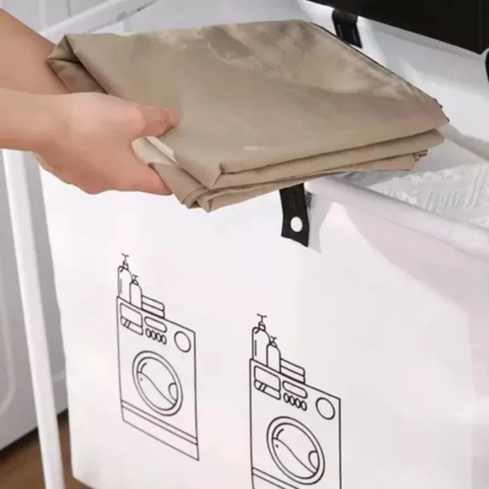 Mano colocando ropa doblada color beige en cesta organizadora blanca con dibujo de lavadora.