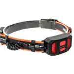 Linterna frontal negra y naranja con LED rojo, banda ajustable y cable en espiral.