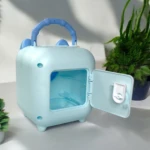 Alcancía azul claro con puerta abierta, asa y orejas divertidas.