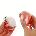 Quita pelusas lavable rosado metálico con aplicador esférico blanco en mano.
