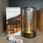 Lámpara táctil imantada de luz cálida con campana de vidrio ahumado, base oscura, cable de carga USB y caja de empaque con diseño de modelos variados.