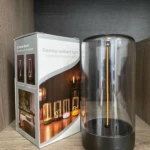 Lámpara táctil imantada de escritorio con filamento LED flexible, junto a su caja de empaque donde se muestra el diseño con base negra y domo transparente.