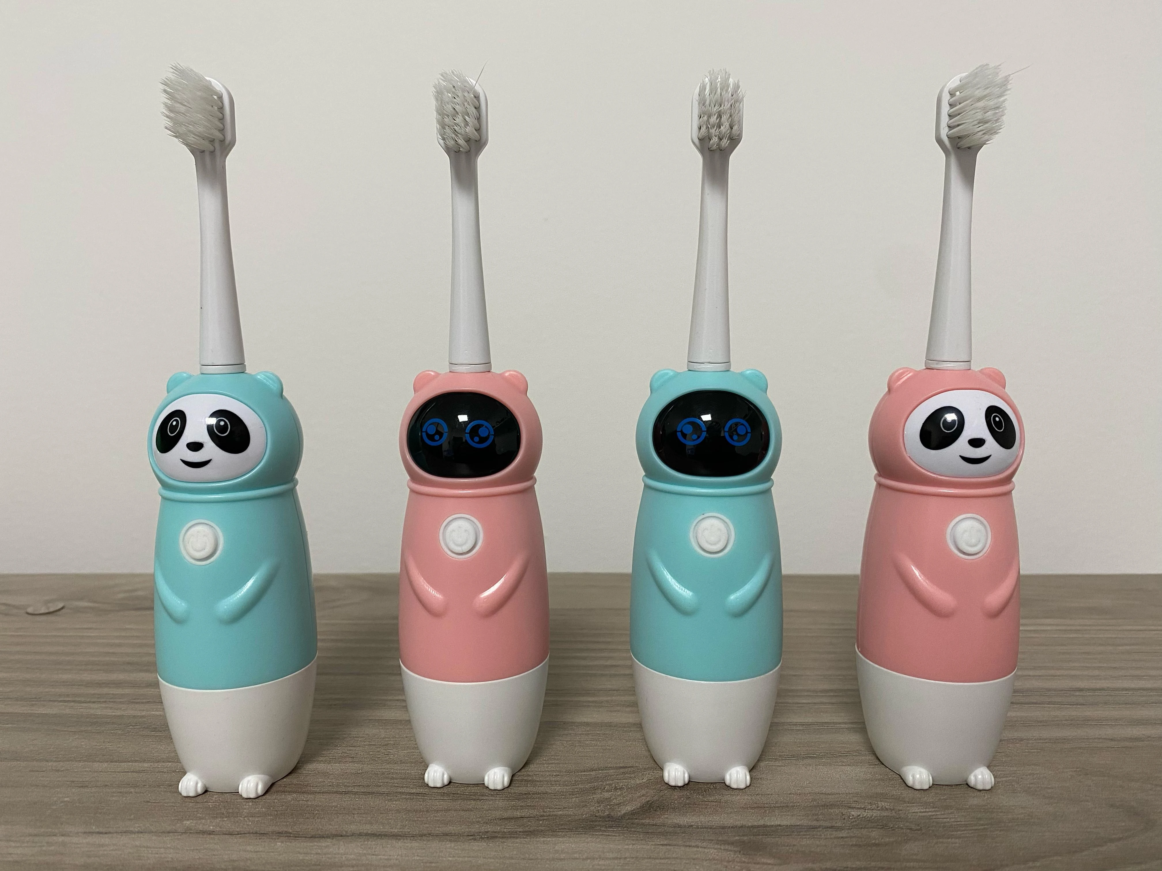 Cepillos de dientes eléctricos infantiles tipo panda en rosa y turquesa.