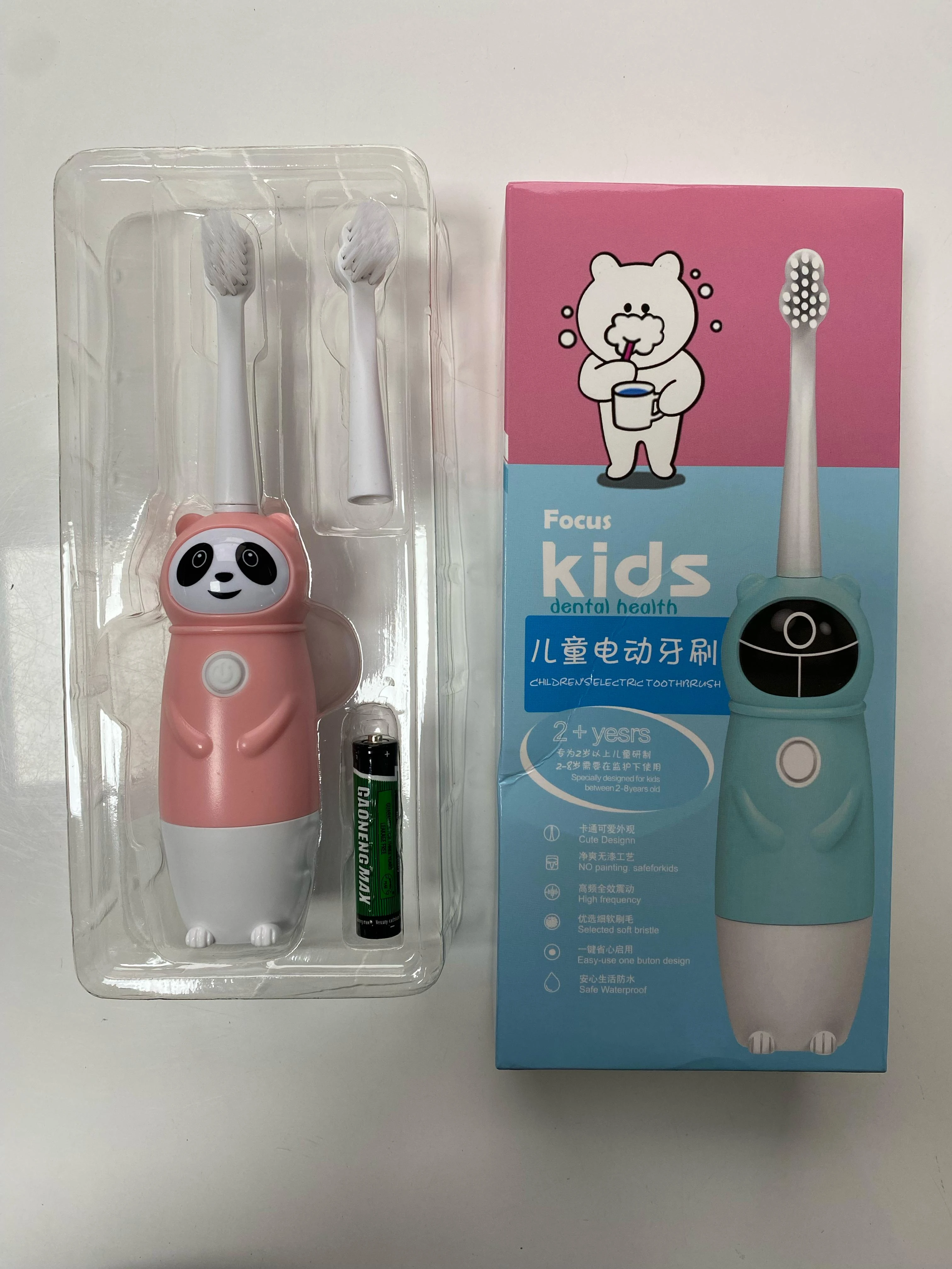 Cepillo de dientes eléctrico infantil rosa con diseño de panda, dos cabezales, y caja azul con dibujo de oso.