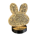 Lámpara LED de mesa con forma de cabeza de conejo, cristal facetado, base negra brillante, luz cálida.