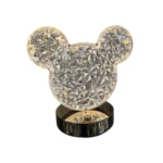Lámpara de mesa LED con base metálica cromada y difusor acrílico cristal facetado en forma de cabeza de ratón.