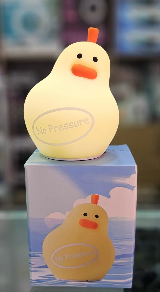 Lampara de noche de silicona con forma de pato amarillo, iluminada, con la frase No Pressure y caja decorativa a juego en la base.