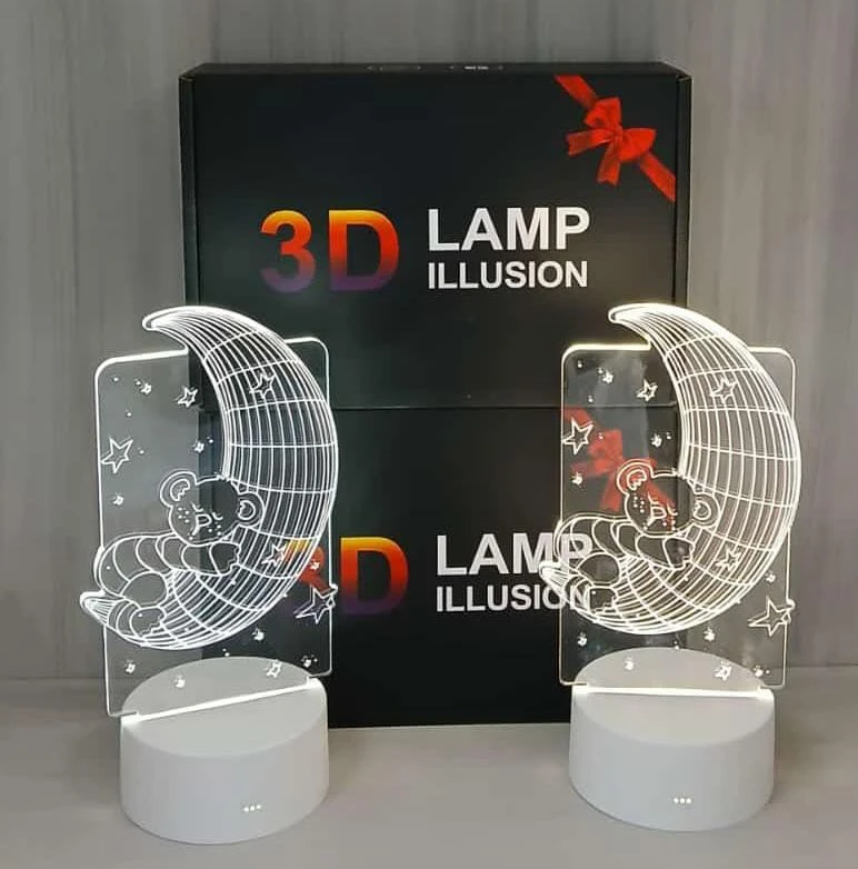 Lámparas 3D decorativas: diseño de oso durmiendo en luna, base blanca, caja negra con lazo rojo.
