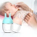 Extractor nasal para bebés con succion manual, color turquesa y rosa, para aliviar la congestión nasal.