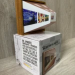 Lámpara de pared nocturna 3D con arte "La noche estrellada" sobre caja de embalaje de madera y plástico.