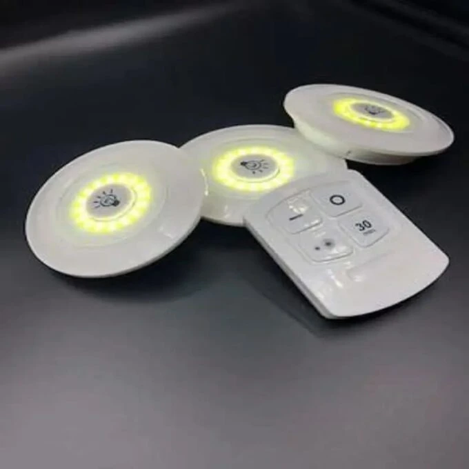 Set de 3 luces LED adhesivas redondas blancas con control remoto, emiten luz amarilla cálida.