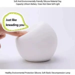 Lámpara de mesa de silicona suave, blanca, con texto "Just like kneading you".