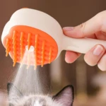 Cepillo vapor naranja para mascotas, rocía agua fina sobre un gato.