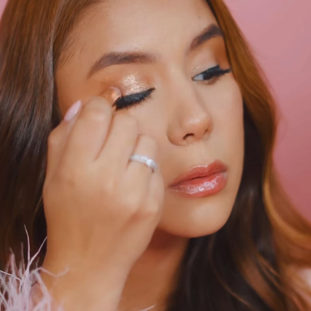 Brocha siliconada con brillo dorado, para aplicar sombra en los ojos, vista de cerca.