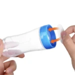 Cuchara dispensadora de alimentos para bebé con tapa azul y flechas indicando cierre.