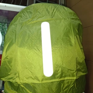 Forro impermeable verde para morral con banda reflectiva central.