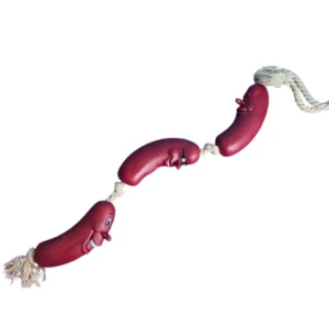 Juguete interactivo para perro, cuerda con tres salchichas rojas de goma con rostros sonrientes.