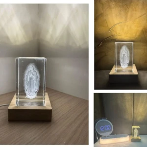 Lámpara de cristal tallado Virgen de Guadalupe sobre base de madera, ilumina ambiente.