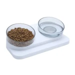 Comedero doble elevado blanco con dos tazones transparentes inclinados: uno con croquetas y otro con agua.
